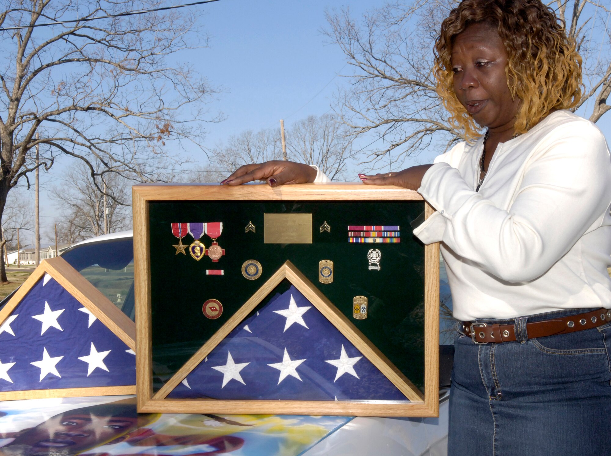 BARKSDALE AIR FORCE BASE, La. (AFPN) -- Denise Godbolt, mother of the late Army Sgt. Lee Myles Godbolt, received two new shadow boxes Feb 8. The boxes replaced the ones damaged in Hurricane Katrina. Retired Tech. Sgt. Mike Jarrett, woodcraft manager here, replaced the shadow boxes for Mrs. Godbolt. (U.S. Air Force photo by Senior Airman Brian Ferguson)