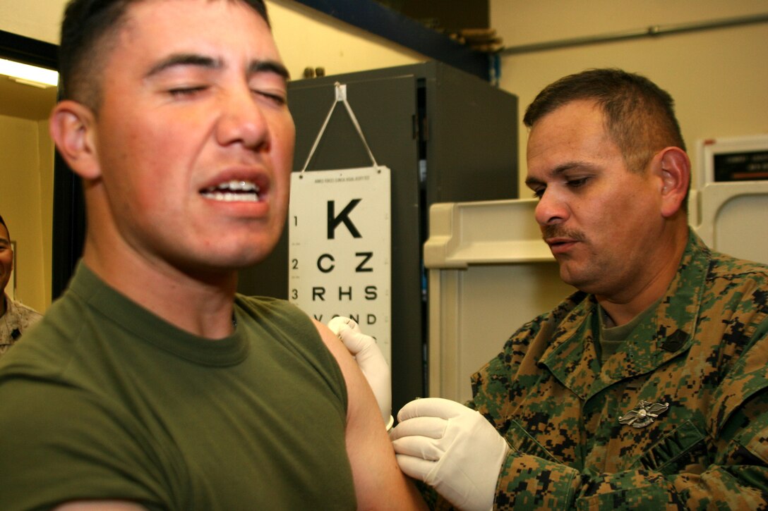 Cpl. Edgar Ramos, a Combat Logistics Battalion 7 Marine and 22-year-old Los Angeles native, cringes as Petty Officer 1st Class Christopher Marin treats him with an inoculation of small pox at the Combat Center.