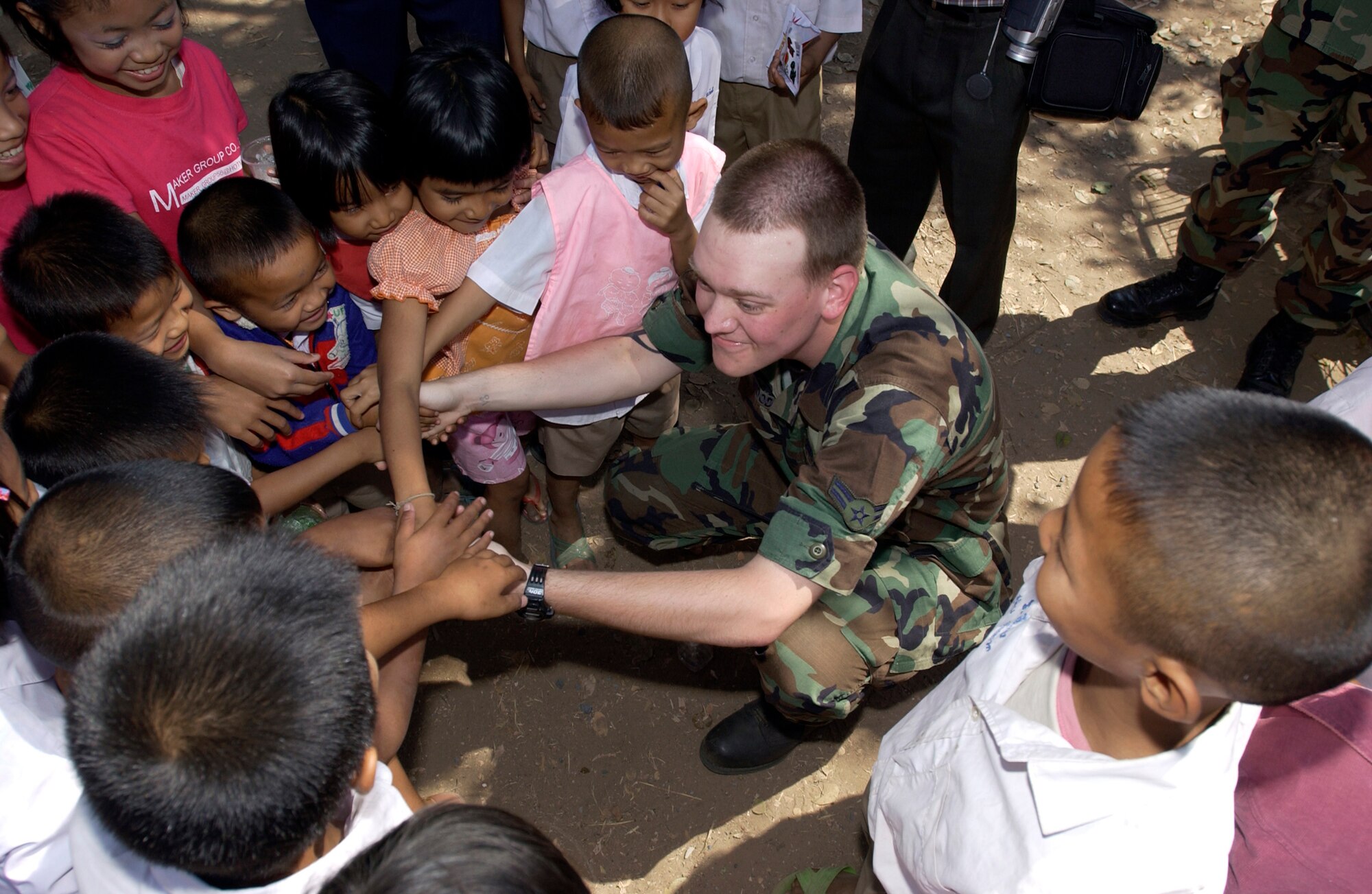 NAKHON RATCHAISMA, Thailand (AFPN) -- Airman 1st Class Brock Wood shakes hands with elementary school children near Korat Royal Thai Air Base, Thailand, during a break from the Cope Tiger '06 exercise. Airman Wood was part of a group of Airmen who delivered supplies to the Ang Huay Yang Elementary School. He is a computer specialist with the 3rd Communications Squadron at Elmendorf Air Force Base, Alaska. (U.S. Air Force photo by Tech. Sgt. Keith Brown) 