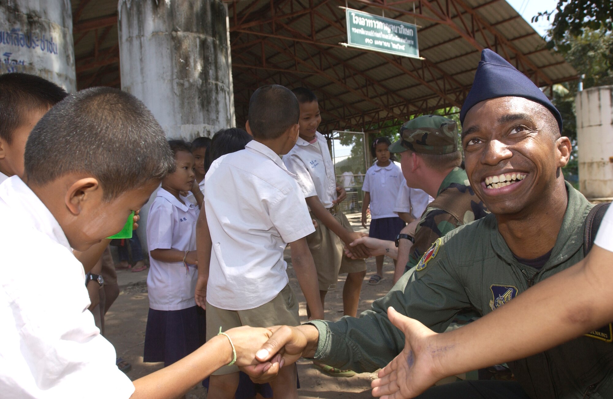 NAKHON RATCHAISMA, Thailand (AFPN) -- Tech. Sgt. Clarence Jenkins smiles as he greets a student at an elementary school near Korat Royal Thai Air Base, Thailand, during a break from Cope Tiger  '06 exercises. Sergeant Jenkins was part of a group of Airmen who delivered sports equipment and other supplies to the Ang Huay Yang Elementary School Feb. 10. Sergeant Jenkins is a flight engineer with the 36th Airlift Squadron at Yokota Air Base, Japan. (U.S. Air Force photo by Tech. Sgt. Keith Brown) 