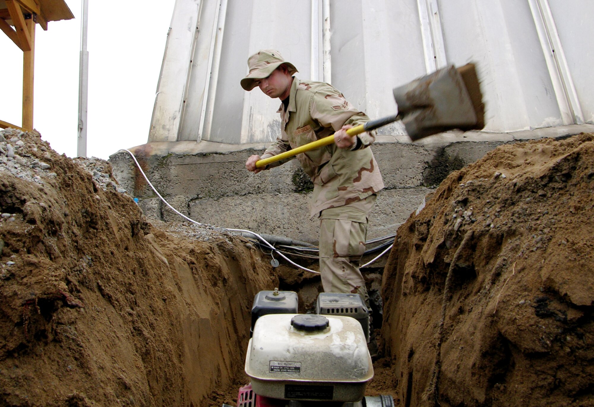 MANAS AIR BASE, Kyrgyzstan (AFPN) -- Airman 1st Class Scott Helton puts the finishing touches on a sewage pipe trench during the renovation of the 367th Air Expeditionary Wing headquarters here. (U.S. Air Force photo by Capt. James Bressendorff)