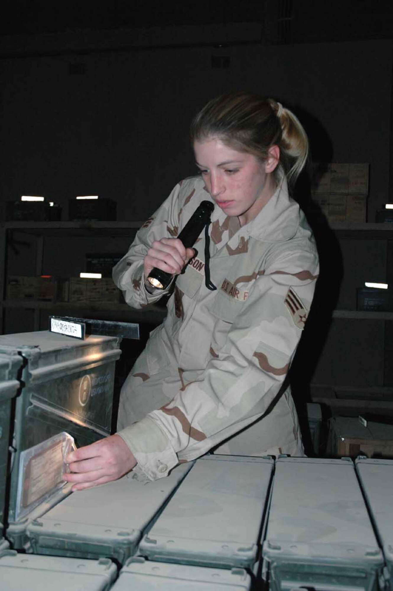 KIRKUK AIR BASE, Iraq (AFPN) -- Senior Airman Mandi Wilkinson checks the inspection date on a box of small arms munitions. Airman Wilkinson is one of five Airmen in the AMMO flight who manages the bomb dump here. (U.S. Air Force photo by Staff Sgt. Kristina Barrett) 
