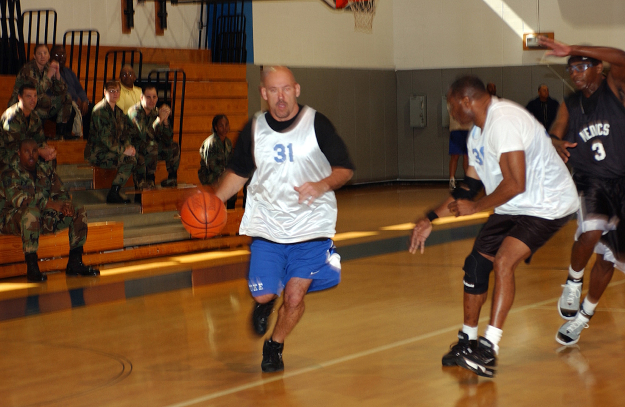 Richard Johnston (left) drives to teh basket, as teammate Mark Forbes fends off the opponents in the play-off game Tuesday in the Aderholt Fitness Center.