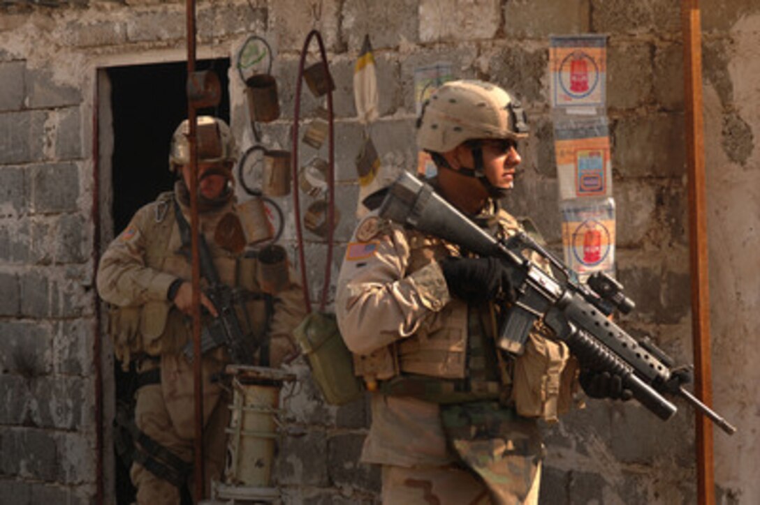 Two soldiers from the U.S. Army's 3rd Armored Cavalry Regiment keep an eye on the surroundings as they conduct a combat patrol in the streets of Tall Afar, Iraq, on Feb. 6, 2006. 