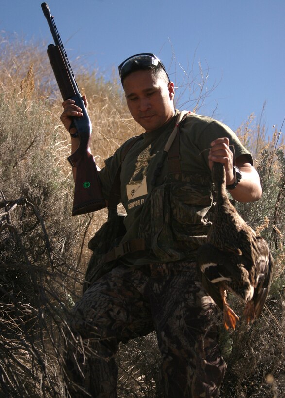 Gunnery Sgt. Jason J. Texeira, motor transportation chief, 3rd Amphibious Assault Battalion, 1st Marine Division, negotiates his way down a hill after downing a duck while hunting at the Green Head Hunting Club in Pine Valley, Calif. Feb. 11. Texeira, 31, of Kona, Hawaii, and 14 other Pendleton Sportsman Club members spent a day shooting sporting clays and duck hunting at the club when it hosted a military appreciation day.