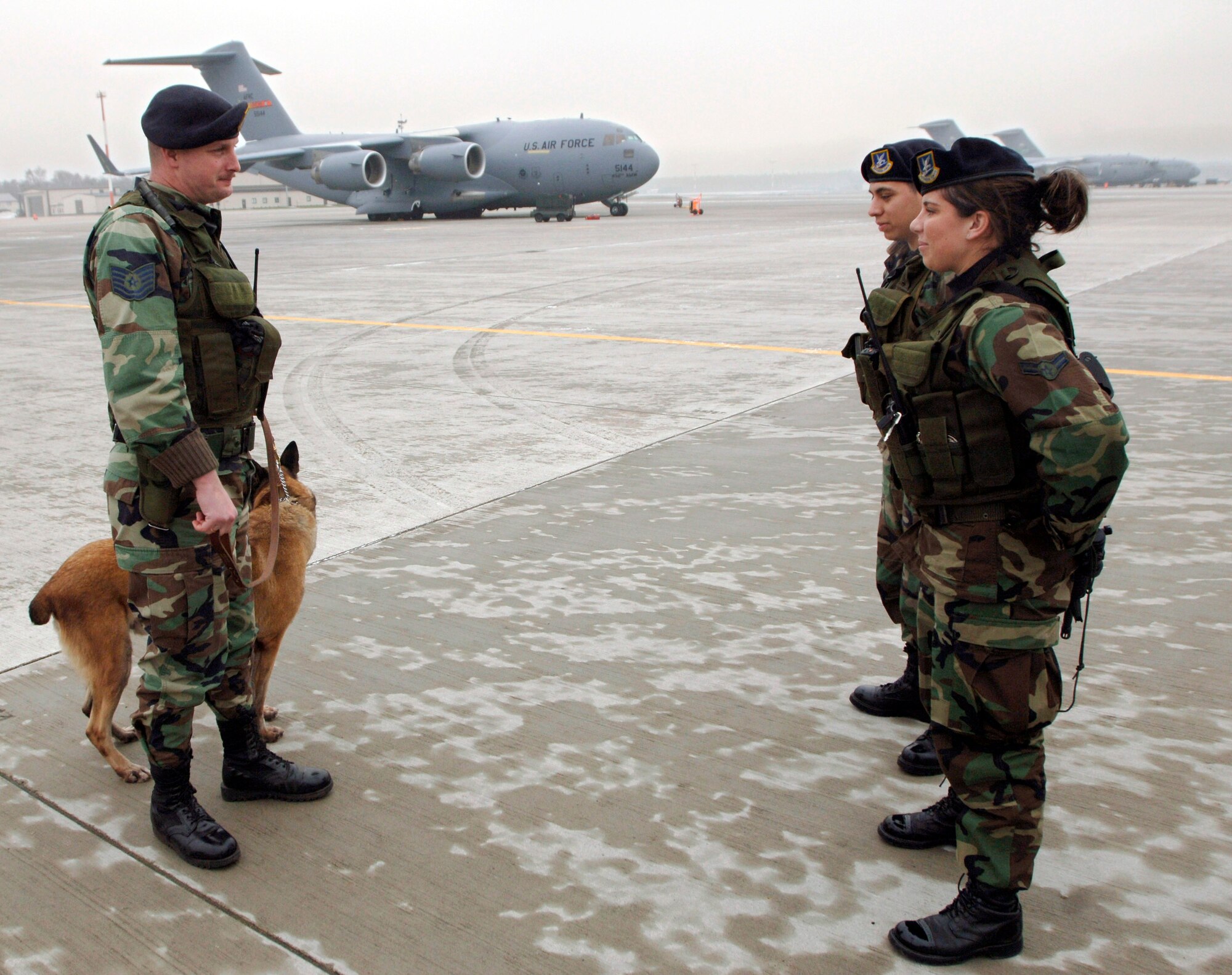 RAMSTEIN AIR BASE, Germany (AFPN) -- Basco waits as Tech. Sgt. John Vanderdrink receives a report. Sergeant Vanderdrink has worked with Basco, a Belgian Malinois, for three years.  They are assigned to the 435th Security Forces Squadron. Sergeant Vanderdrink, originally from Wilmington, N.C., has been a dog handler for seven years. (U.S. Air Force photo by Master Sgt. John E. Lasky) 