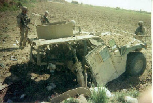 MCCHORD AIR FORCE BASE, Wash. - Soldiers in Iraq secure the wreckage of the Humvee Army Sgt. Jeff Beltran was riding in before it was struck by an improvised explosive device. All three soldiers riding in the vehicle survived the blast that occurred while on patrol near Taji, Iraq.  Sergeant Beltran was treated in the field by Army Spc. Mitch Barone, and then on an aeromedical evacuation flight by Tech. Sgt. Selina Barone, Specialist Barone's mother.  Sergeant Barone is a Reservist with the 446th Aeromedical Evacuation Squadron at McChord.