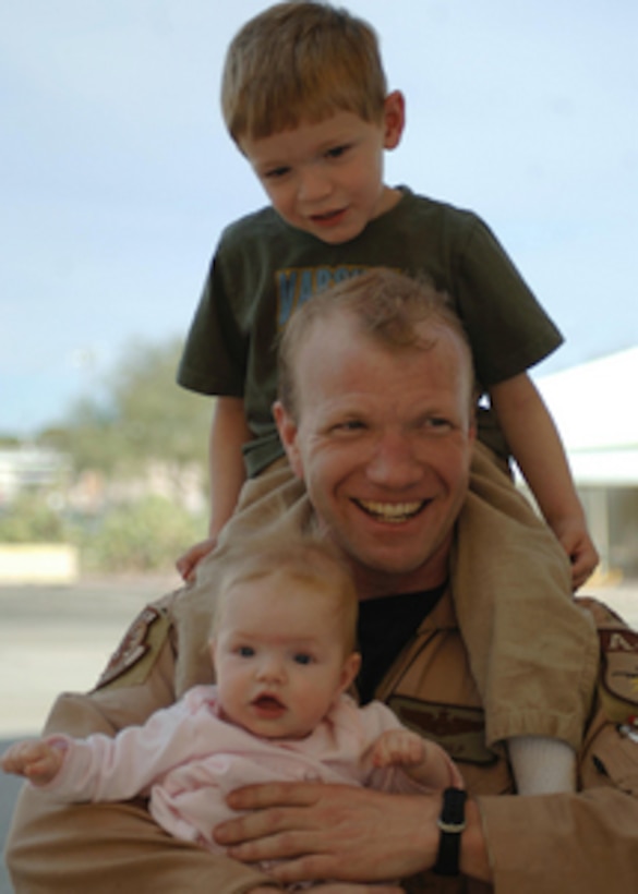 Air Force Maj. Jon Culp has a happy reunion with his children at Davis-Monthan Air Force Base, Ariz., as he returns home after a deployment to Bagram, Afghanistan, on Feb. 8, 2006. Culp is a pilot with the 354th Fighter Squadron. 