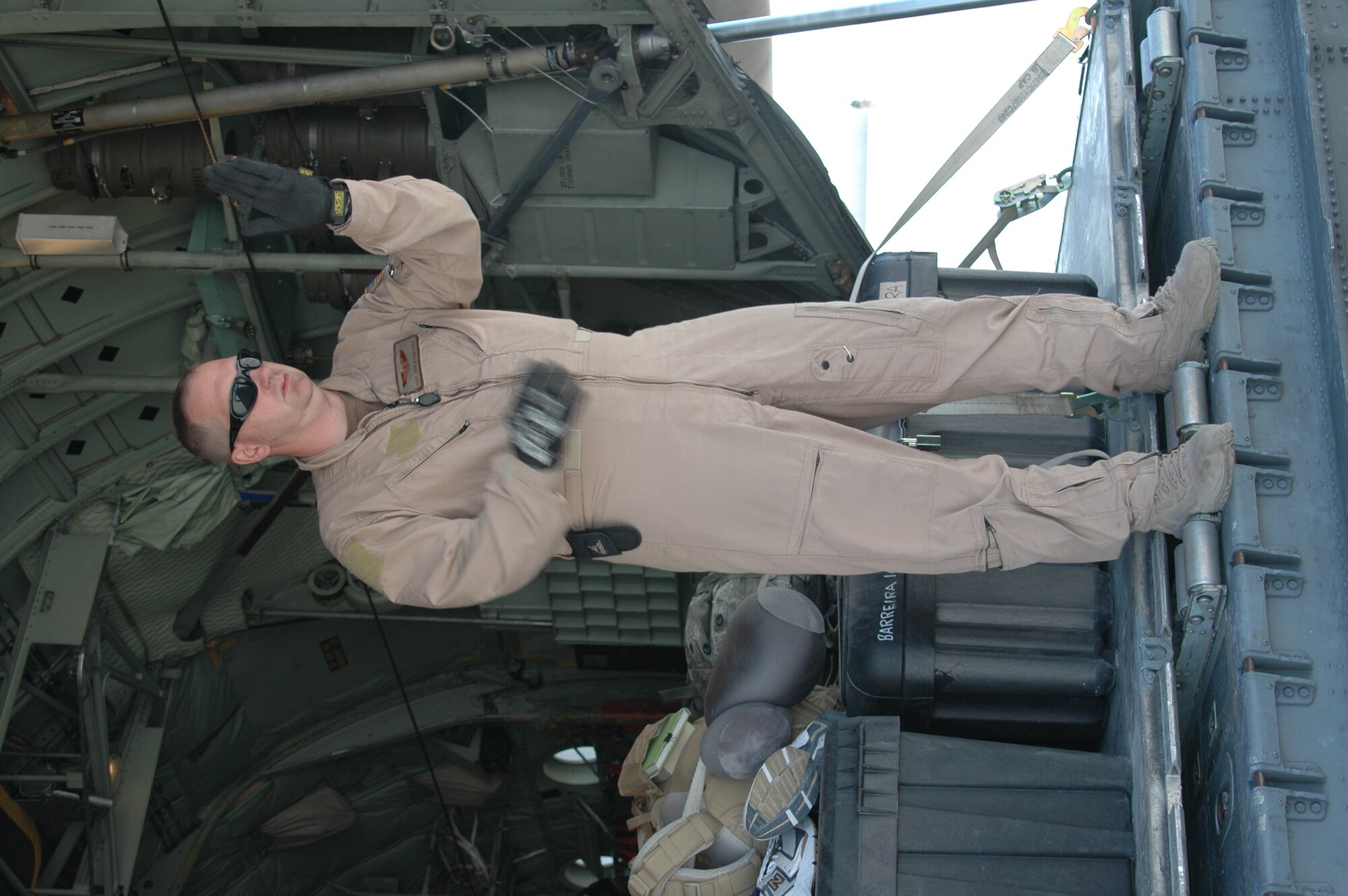 BALAD AB, IRAQ- Tech. Sgt. John Mangefrida,746th Expeditionary Airlift Squadron, C-130H Loadmaster signals fork lift operator directions at Balad Air Base.
(Air Force photo by Master Sgt. Peter Borys) (Released) 