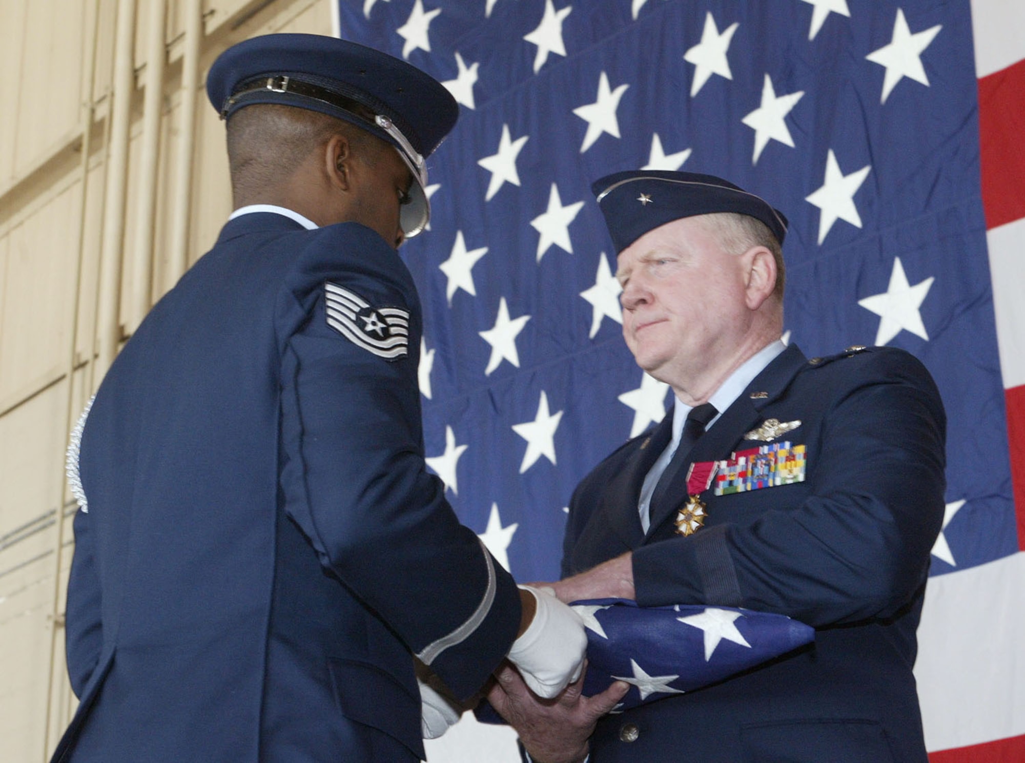 DOBBINS AIR RESERVE BASE, Ga. -- Tech. Sgt. Darrell Harper, 94th Airlift Wing Honor Guard, presents colors to Brig. Gen. Thomas Stogsdill, who surrendered command of the 94AW and retired from the Air Force Reserve. The general has served since 1969. (U.S. Air Force photo by Don Peek)