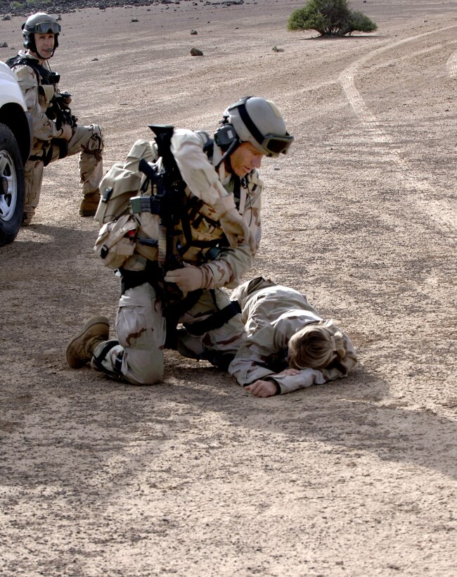 CAMP LEMONIER, DJIBOUTI, Africa (AFPN) -- Capt. Jessica Maverick lies on the ground simulating a car crash injury, while Air Force pararescuemen prepare to transport her in a Marine CH-53 Super Stallion helicopter. The scenario was part of a search and rescue exercise here Feb 8.  (U.S. Air Force photo by Staff Sgt. Ricky A. Bloom)