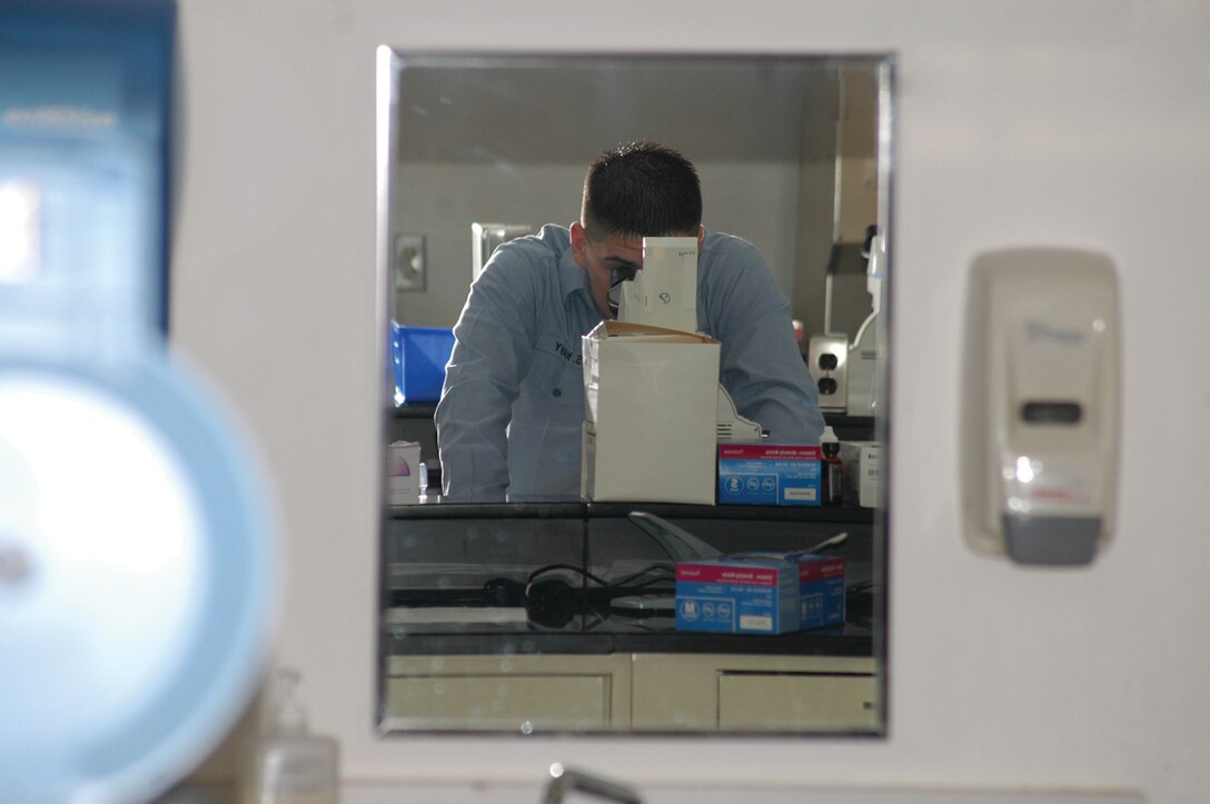 Seaman Apprentice David Moore, laboratory technician, Branch Medical Clinic, uses a microscope to check a urine sample at the laboratory Feb. 15. The laboratory serves active duty service members, reservists on the air station family members and retirees enrolled in the clinic.
