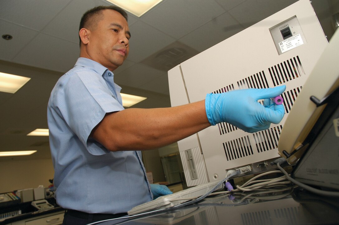 Petty Officer 1st Class Florenta Cabalbag, medical laboratory technician and overall laboratory supervisor, Branch Medical Clinic, picks up a blood sample to test at the station?s clinic Feb. 15.