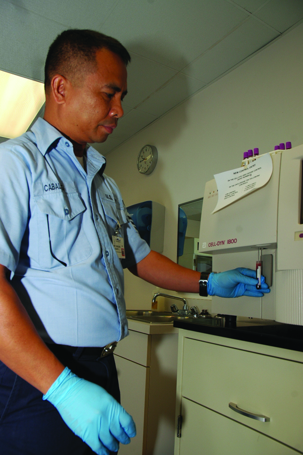 Petty Officer 1st Class Florenta Cabalbag, medical laboratory technician and overall laboratory supervisor, Branch Medical Clinic, inserts a blood sample into the complete- blood-count machine for analysis at the station?s clinic Feb. 15.