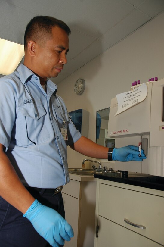 Petty Officer 1st Class Florenta Cabalbag, medical laboratory technician and overall laboratory supervisor, Branch Medical Clinic, inserts a blood sample into the complete- blood-count machine for analysis at the station?s clinic Feb. 15.
