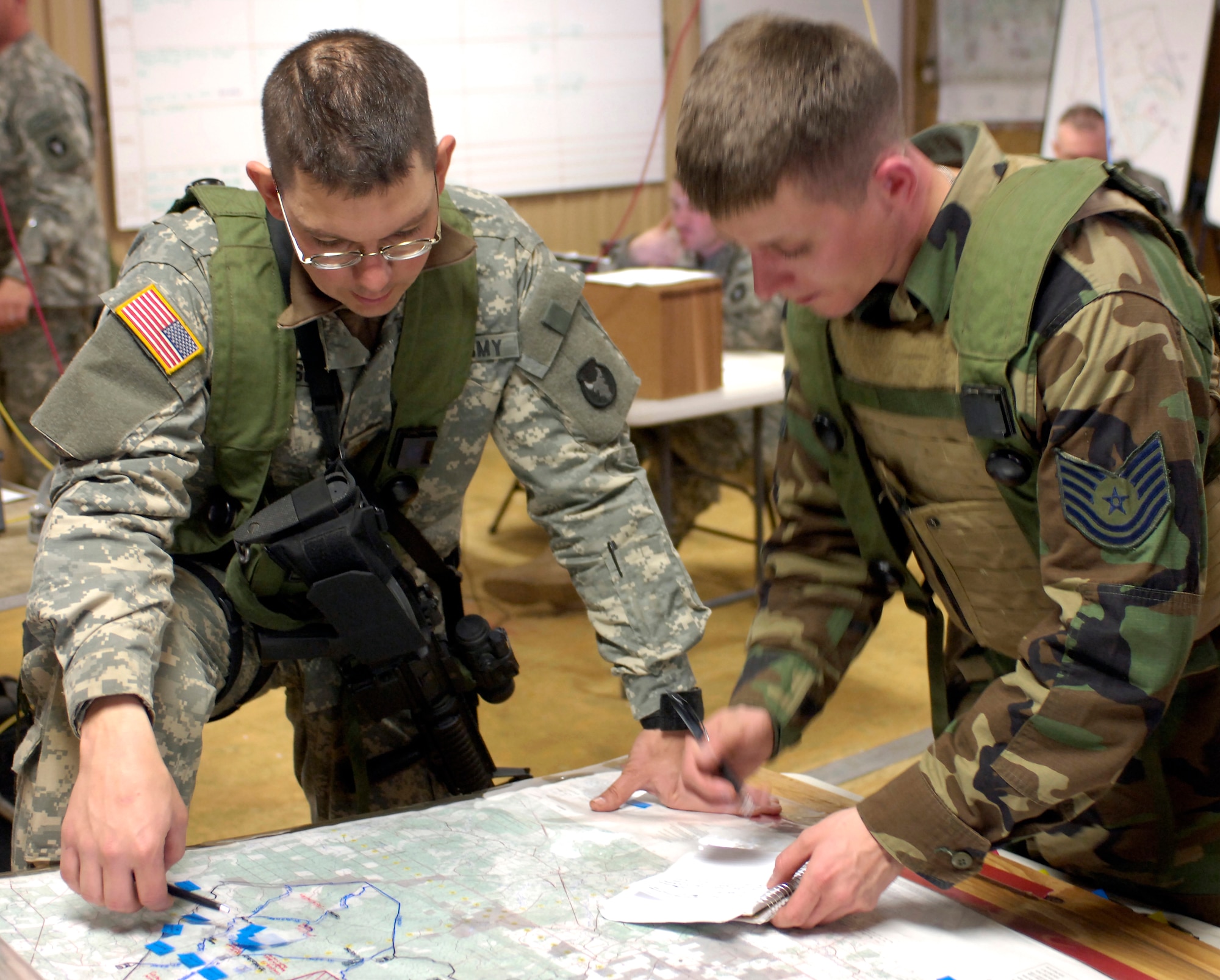 FORT POLK, La. (AFPN) -- Army Maj. Shannon Richardson updates Tech. Sgt. Dan Kurtin during an Air Warrior II exercise Feb. 9. Sergeant Kurtin is a Guardsman with the 169th Air Support Operations Squadron in Peoria, Ill. Major Richardson is an operations officer with the 1-133rd Infantry Battalion. (U.S. Air Force photo by Senior Airman Brian Ferguson)