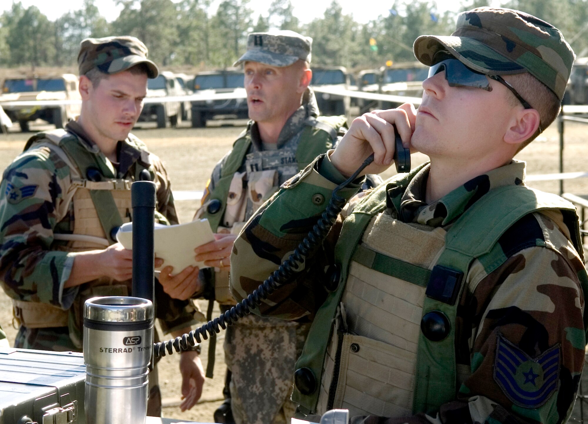 FORT POLK, La. (AFPN) -- Tech. Sgt. Dan Kurtin calls in air support while Senior Airman Ty Terpening coordinates operations with Army Capt. Jeff Staker during an Air Warrior II exercise here Feb. 9.  Air Warrior II is a joint and total force exercise designed to give deploying units a realistic training environment. The exercise incorporates air power with Army maneuvers to help Army and Air Force units work better together in the field. Sergeant Kurtin and Airman Terpening are Guardsmen with the 169th Air Support Operations Squadron in Peoria, Ill. Captain Staker is an intelligence officer with the 1-133rd Infantry Battalion. (U.S. Air Force photo by Senior Airman Brian Ferguson)