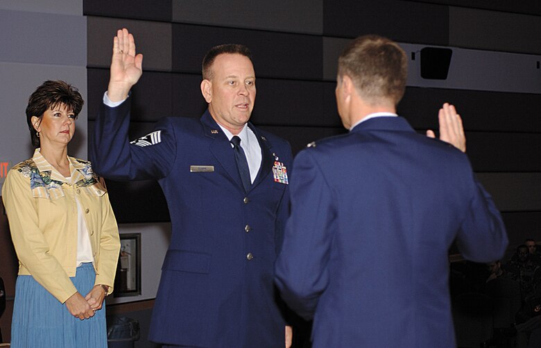 CANNON AIR FORCE BASE, N.M. -- Ms. Victoria Clark watches as Col. Jeff Harrell, 27th Fighter Wing vice commander, swears her husband,Chief Master Sgt. Ray Clark, in as the new 27th FW command chief. (U.S. Air Force photo by Tech. Sgt. Scott Mackay)