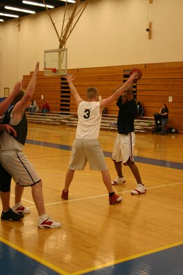CANNON AIR FORCE BASE, N.M. -- Anthony Price, EMS, looks for an open teammate to help him score. EMS trampled the LRS #2 team in Tuesday’s game 71 to 39. (U.S. Air Force photo by Airman Thomas Trower)
