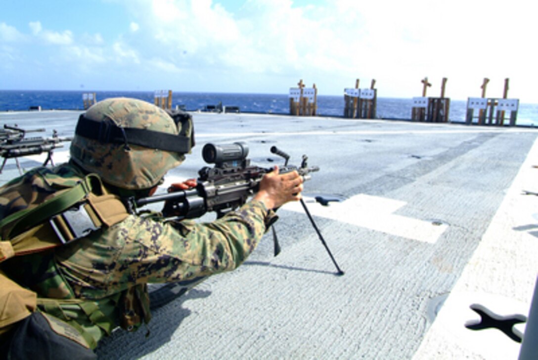 A U.S. Marine with the 31st Marine Expeditionary Unit adjusts his weapon during a squad automatic weapons live-fire exercise on the flight deck of the amphibious dock landing ship USS Harpers Ferry (LSD 49) on Feb. 15, 2006. Harpers Ferry, USS Essex (LHD 2) and USS Juneau (LPD 10) are operating in the Philippine Sea. 