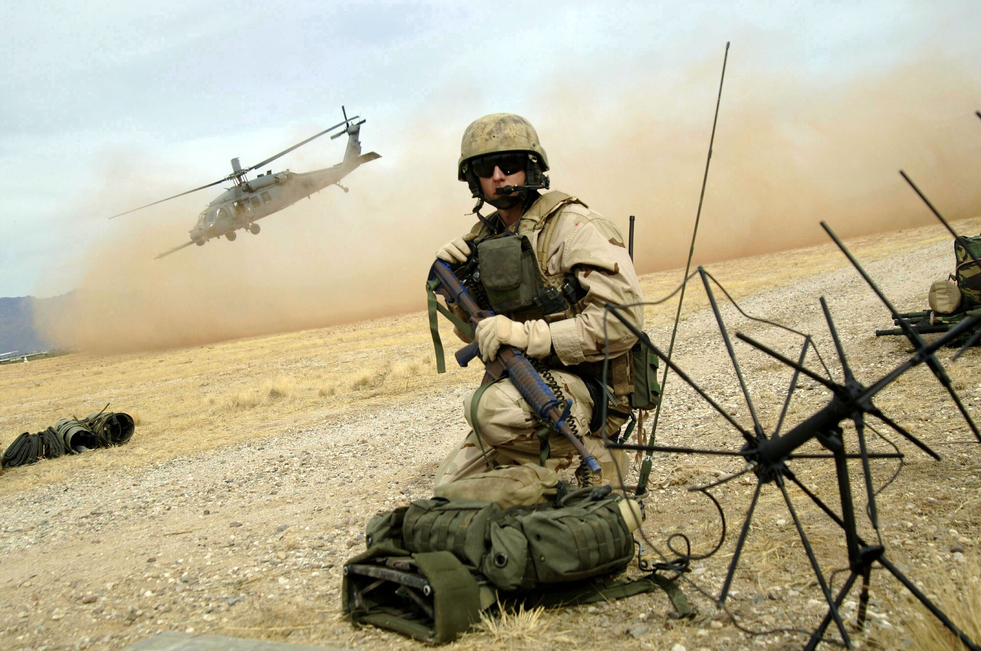 DAVIS-MONTHAN AIR FORCE BASE, Ariz. (AFPN) -- A combat rescue officer communicates with the HH-60 Pavehawk helicopter crew to organize the extraction of casualties during a joint US and Dutch mass casualty exercise Feb. 14. The scenario involved a simulated shoot-down of a C-141 Starlifter cargo plane by a missile. Pararescuemen from the 48th Rescue Squadron and the Dutch Army worked together to train on combat search and rescue extraction. (U.S. Air Force photo by Airman 1st Class Christina D. Ponte)