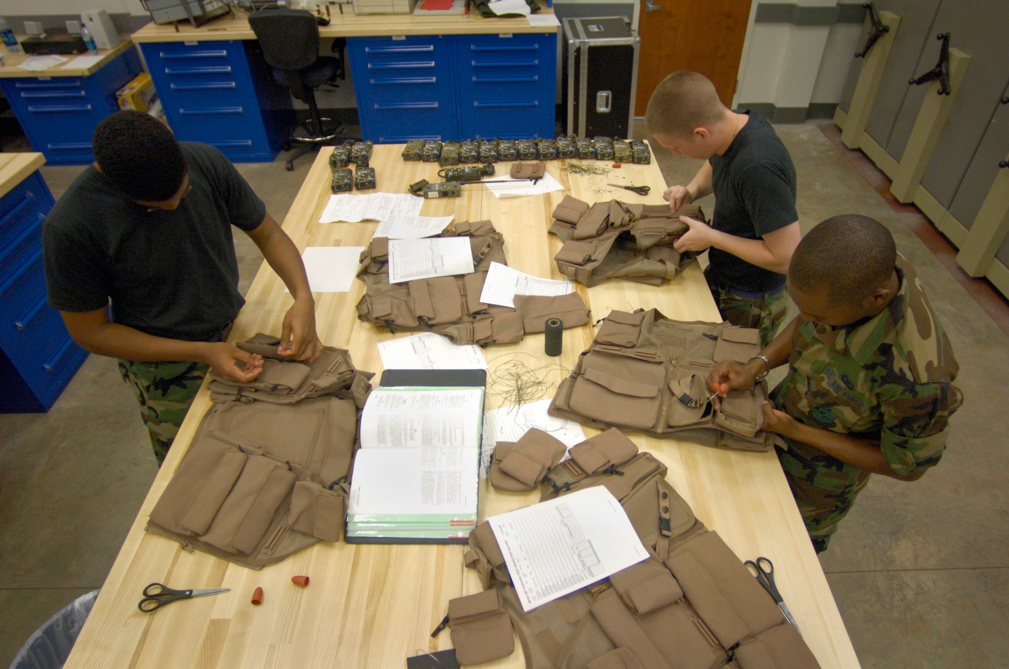 HICKAM AIR FORCE BASE, Hawaii (AFPN) -- Airman Basic John Williams, Airman Michael McLaughlin and Airman Basic Christian White sew down pockets on air ace survival vests. The life support shop is a combination of Hawaii Air National Guard and active-duty Airmen who support the 15th Airlift Wing, 154th Wing and transient aircraft. All three Airmen are with the 15th Operations Support Squadron. (U.S. Air Force photo by Tech. Sgt. Shane A. Cuomo) 

