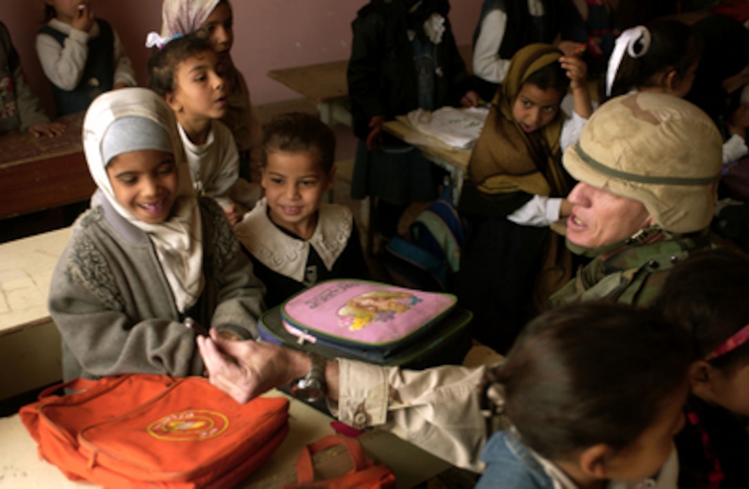 Engineer Barry Stuard passes out donated school supplies to students at the Malak Al Ashter Intermediate School in Diwaniyah, Iraq, on Feb. 14, 2006. Stuard is attached to the U.S. Army Corps of Engineers, Multinational Division - Central South. 