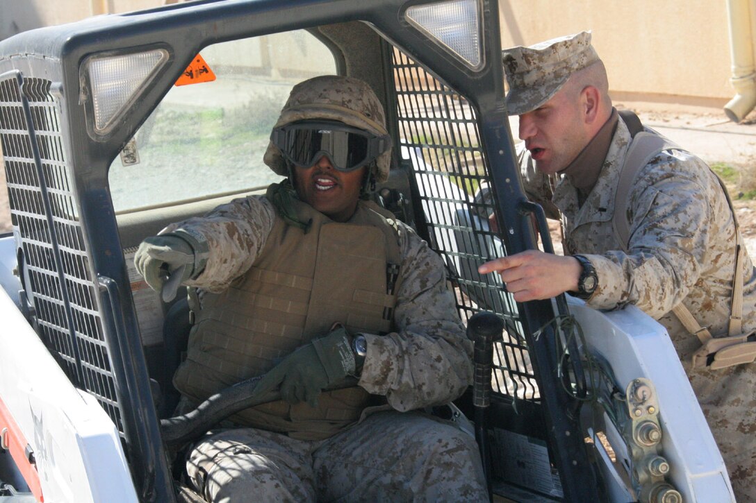 Lance Cpl. Pranil K. Shankar (left) discusses filling in a mud-filled bog behind the Marine Aviation Logistics Squadron 16 headquarters building with 1st Lt. Randolph C. Chase Feb. 17. The Marine and four others with the logistics section are responsible for the embarkation of all squadron gear and personnel, squadron building maintenance and a variety of other jobs that spring up. Chase is the logistics officer for MALS-16, Marine Aircraft Group 16, 3rd Marine Aircraft Wing. Shankar is a logistics/embarkation and combat service support specialist with the support squadron.