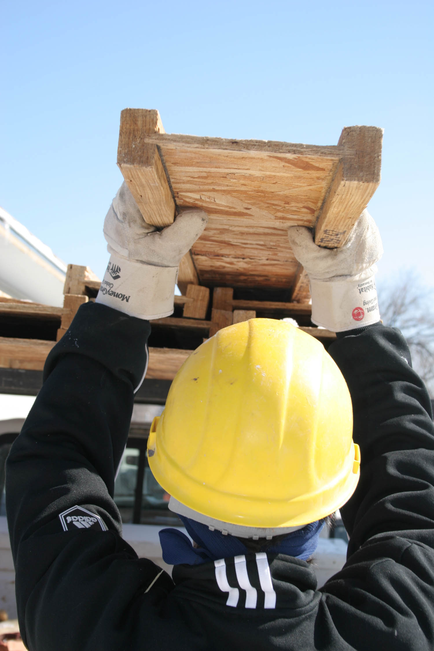A poolee from RSS Metro South unloads lumber from a truck, February 18, for Habitat for Humanity of Denver.