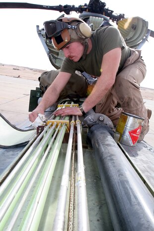 Sgt. Andrew F. McNutt greases cables on a CH-46 Sea Knight helicopter Feb. 21 at Al Taqaddum, Iraq. McNutt is a crew chief, and Denver, native, with Marine Medium Helicopter Squadron 161, Marine Aircraft Group 16, 3rd Marine Aircraft Wing. The Greyhawks completed a transfer of authority for casualty evacuation and general aviation support missions to HMM-268, MAG-16, 3rd MAW, Feb. 25.