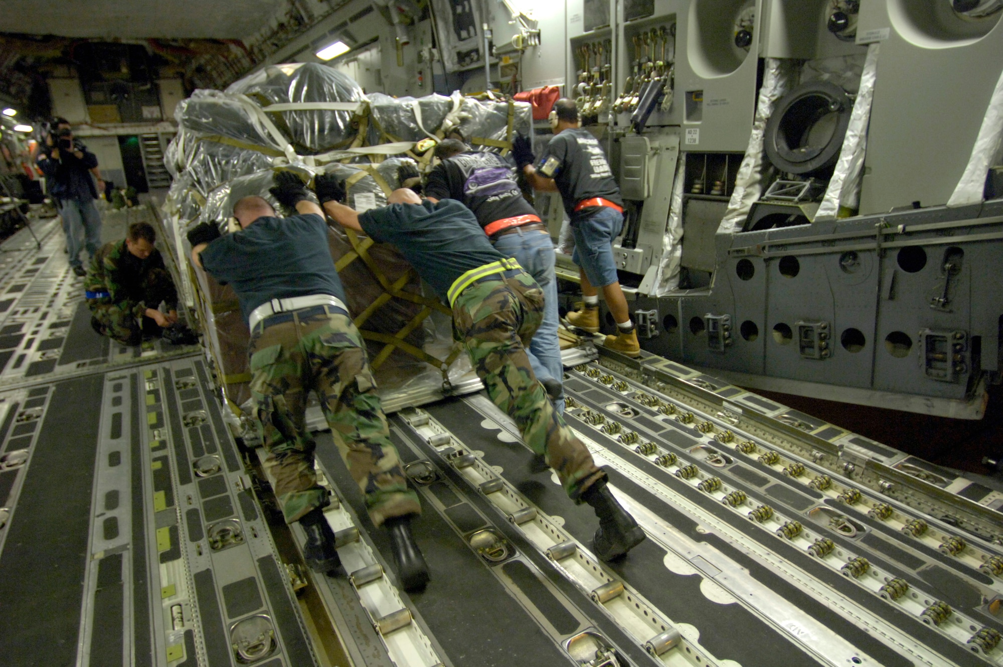 HICKAM AIR FORCE BASE, Hawaii (AFPN) -- Members from the 735th Air Mobility Squadron push a cargo pallet on to a C-17 Globemaster III to support relief efforts in the Philippines. The composite C-17 squadron of active duty and Hawaii Air National Guard loaded the pallets Feb. 21 to carry military rations, water, cots, tents and personnel from the 15th Airlift Wing to help out with the mudslide disaster. (U.S. Air Force photo by Tech. Sgt. Shane A. Cuomo)