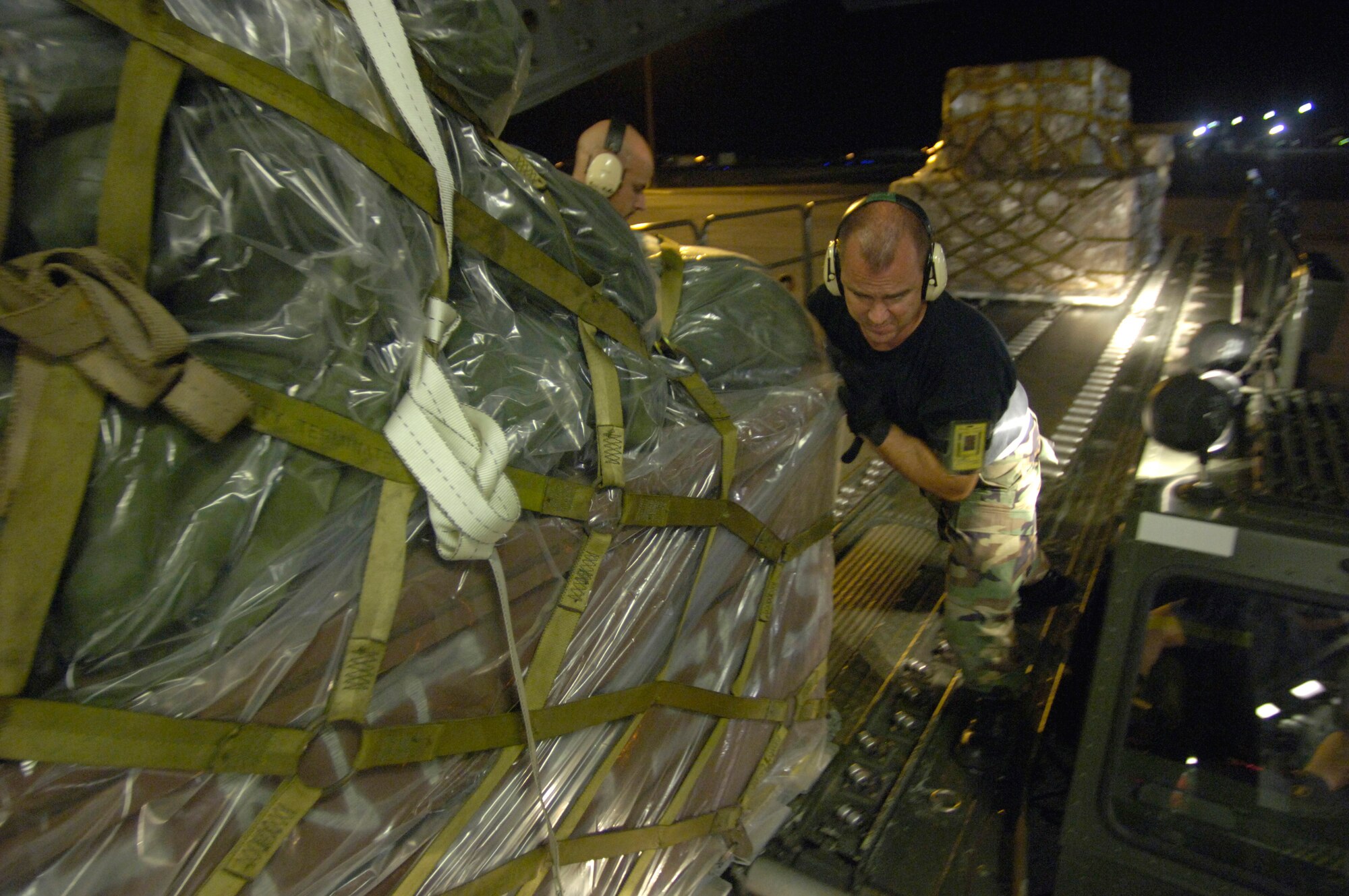 HICKAM AIR FORCE BASE, Hawaii (AFPN) -- Tech. Sgt. Phillip Patterson pushes a cargo pallet on to a C-17 Globemaster III to support relief efforts in the Philippines. The composite C-17 squadron of active duty and Hawaii Air National Guard loaded the pallets Feb. 21 to carry military rations, water, cots, tents and personnel from the 15th Airlift Wing to help out with the mudslide disaster. Sergeant Patterson is from the 735th Air Mobility Squadron at Hickam AFB, Hawaii. (U.S. Air Force photo by Tech. Sgt. Shane A. Cuomo)