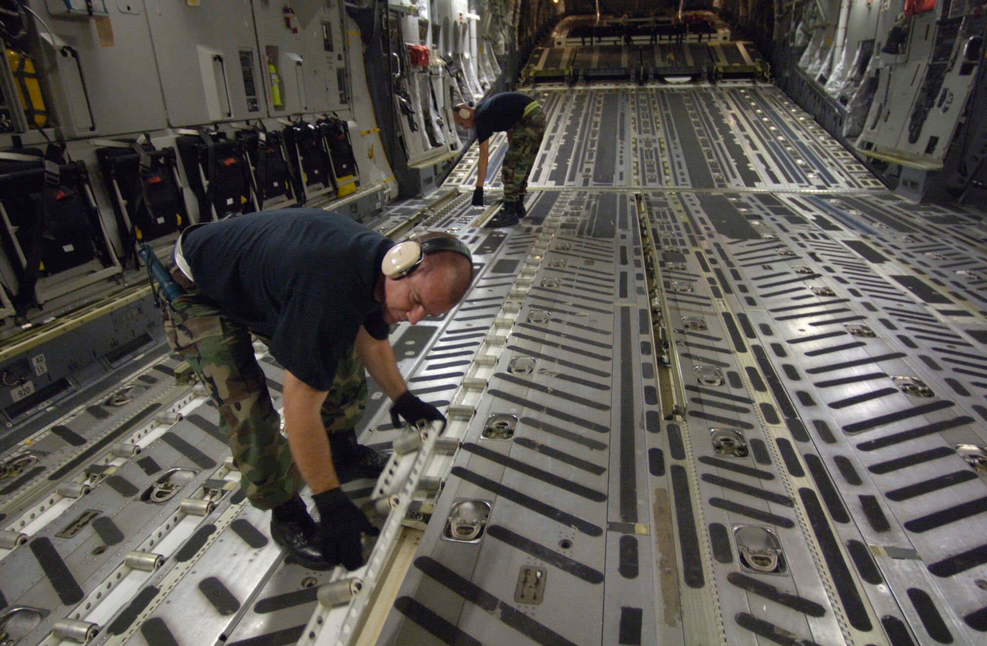 HICKAM AIR FORCE BASE, Hawaii (AFPN) -- Tech. Sgt. Phillip Patterson and Staff Sgt. Nathan Rust prepare a C-17 Globemaster III to receive cargo pallets to support relief efforts in the Philippines. The composite C-17 squadron of active duty and Hawaii Air National Guard loaded the pallets Feb. 21 to carry military rations, water, cots, tents and personnel from the 15th Airlift Wing to help with the mudslide disaster. Sergeants Patterson and Rust are from the 735th Air Mobility Squadron at Hickam AFB, Hawaii. (U.S. Air Force photo by Tech. Sgt. Shane A. Cuomo)