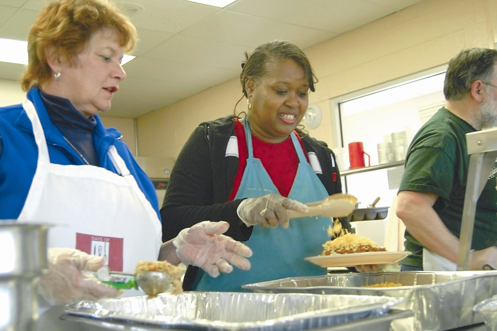 WRIGHT-PATTERSON AIR FORCE BASE, Ohio - Sallie Wilson, left, gets the stuffing ready while Sandra Bonner puts the finishing touches on a plate of pasta at a Wingman Day event Feb. 10 at the Dayton House of Bread. Ms. Wilson and Ms. Bonner, of the 88th Civil Engineering Directorate Military Family Housing Division, spent the afternoon providing meals to the homeless. (Air Force photo by Senior Airman Shaun Emery)


