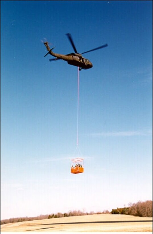 WRIGHT-PATTERSON AIR FORCE BASE, Ohio - (left) A Heli-Basket(r) is suspended beneath an HH-60 rescue helicopter. The Air Force Research Laboratory's Human Effectiveness Directorate provided guidance on flight tests and did data analysis for evaluating the basket's safety as a human rescue tool. The Heli-Basket would enable rescuers to quickly extract up to 15 people trapped in areas unsuitable for helicopter landings. Originally a cargo carrier, it was adapted and tested to meet a Homeland Defense requirement for short-range human rescue in disaster situations. (Precision Lift, Inc. courtesy photo)



