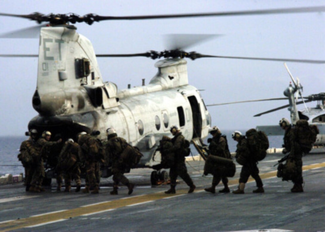 U.S. Marines from the 31st Marine Expeditionary Unit board a Marine CH-46E Sea Knight helicopter on the flight deck of the amphibious assault ship USS Essex (LHD 2) off the coast of Leyte, Philippines, Feb. 20, 2006. More than 200 Marines with are assisting in the humanitarian relief efforts following the Feb. 17, 2006, landslide in the village of Guinsaugon, Philippines. 