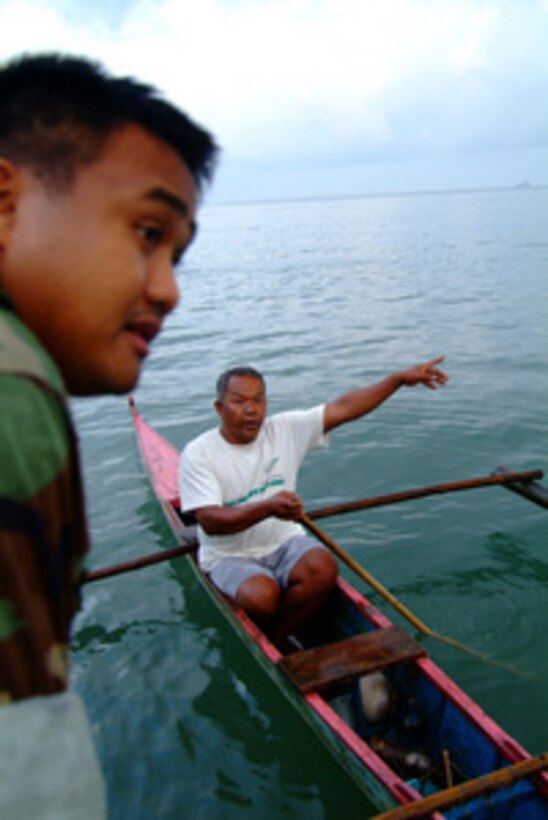 U.S. Navy Petty Officer 2nd Class Christopher Arntzen speaks with a local Filipino fishermen during a beach survey off the coast of Himbangan, Philippines, on Feb. 20, 2006. Arntzen and his fellow sailors from the USS Harpers Ferry (LSD 49) are looking for places where landing craft can bring in search and rescue equipment and humanitarian relief supplies for the victims of the Feb. 17, 2006, Guinsaugon, Philippines mudslide disaster. 