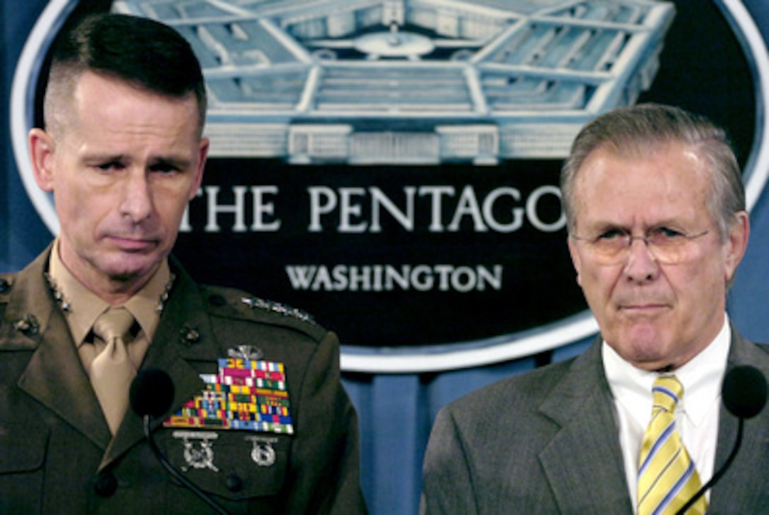 Secretary of Defense Donald H. Rumsfeld (right) and Chairman of the Joint Chiefs of Staff Gen. Peter Pace, U.S. Marine Corps, listen to a reporter's question during a Pentagon press briefing in Arlington, Va., on Feb. 21, 2006. Rumsfeld and Pace talked to reporters about the DoD rescue and relief efforts in the Guinsaugon, Philippines mudslide disaster and the global war on terrorism. 