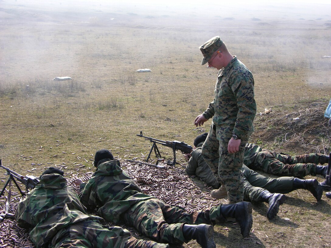 Republic of Georgia soldiers are evaluated at Krtsanisi, Republic of Georgia on their performance firing the PKM machinegun by Cpl. Joshua Kruzich, 21, (standing), a trainer with the Georgia Sustainment and Stability Operations Program and native of Dahlonega, Ga.  The elite 53-member U.S. Task Force, many of them veterans of Iraq and Afghanistan, is training the Georgian soldiers who will fill positions in Iraq. Georgia?s GSSOP trained troops will form part of the dedicated force called for in UN Security Council Resolution 1546 to protect UN forces in Iraq. The mission of the GSSOP is to assist the Georgian armed forces sustain their ongoing deployment of forces supporting stability operations in Iraq.