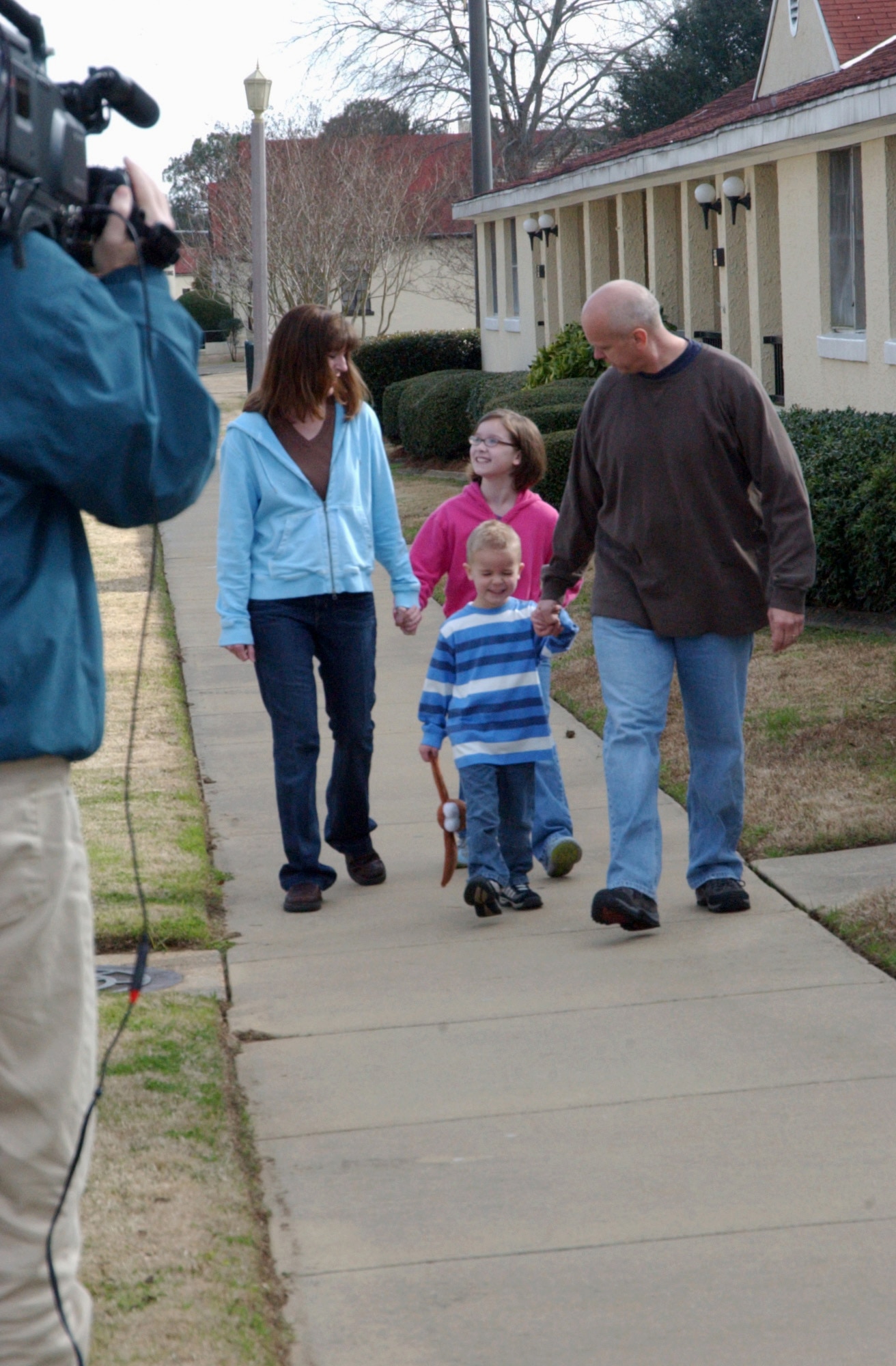 MAXWELL AIR FORCE BASE, Ala. (AFPN) -- "House Hunters" cameraman Spencer Cooper films the Day family, Diane, Sarah Jo, Jacob and Senior Master Sgt. Greg Day, in front of their temporary living facility.  The "House Hunters" profile of the Days is scheduled to air this fall on Home and Garden Television. (U.S. Air Force photo by Tech. Sgt. Scott Moorman)