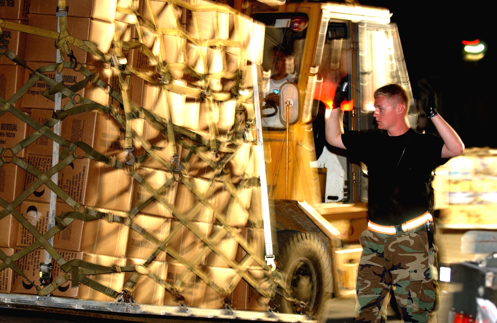 CLARK AIR BASE, Philippines (AFPN) -- An Airman guides a forklift driver loading a pallet of meals ready to eat at Clark Air Base, Feb. 19. The Airman is among more than 2,000 Philippine and U.S. servicemembers with Joint Task Force Balikatan 2006 working together to assist in the humanitarian relief efforts for victims of the Feb. 17 landslide in the village of Guinsaugon on the island of Leyte, Philippines. (U.S. Air Force photo by Senior Airman Jacqueline Kabluyen)
