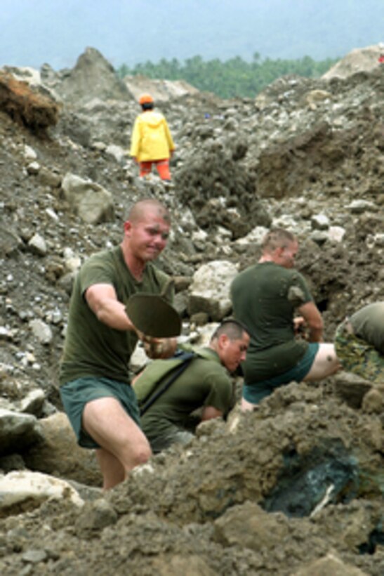 Marine Lance Cpl. Cameron Vancott throws out another shovel full of dirt as he and his fellow Marines search in the village of Guinsaugon, Philippines, on Feb. 20, 2006. More than 200 Marines with are assisting in the humanitarian relief efforts following the Feb. 17, 2006, landslide that covered the village of Guinsaugon. Vancott is a mortarman with Company Golf, 2nd Battalion, 5th Marine Regiment, 31st Marine Expeditionary Unit. 