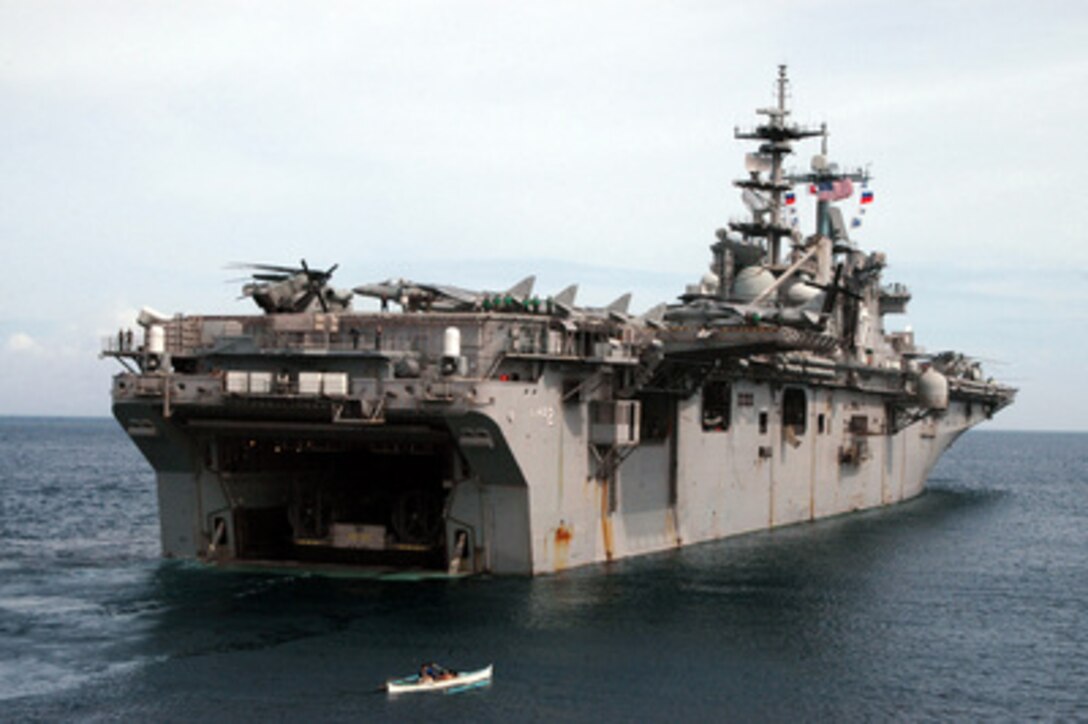 A Filipino fishing boat passes the stern of the amphibious assault ship USS Essex (LHD 2) that is operating off the coast of the island of Leyte, Philippines, on Feb. 21, 2006. Sailors and Marines from the Essex and the dock landing ship USS Harpers Ferry (LSD 49) are providing humanitarian assistance for the victims of the Feb. 17, 2006, landslide in the village of Guinsaugon on the island of Leyte. 