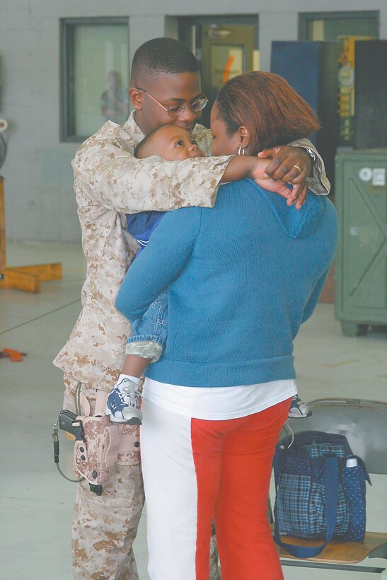 Staff Sgt. McAllan Magloire, a chief cook with Marine Wing Support Squadron 273, hugs his wife, Tosha, and his son, McAnthony, while waiting to leave for a seven-month deployment to Iraq here, Feb. 23. The detachment of 72 MWSS-273 Marines will support MWSS-274 in Camp Al Asad, Iraq.