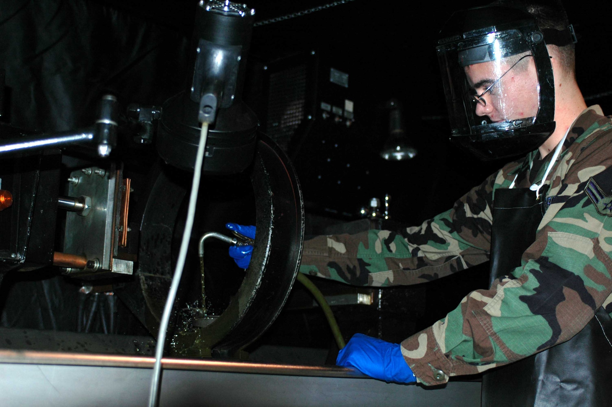 Airman 1st Class Kevin Bunish, 60th Equipment Maintenance Squadron Non-Destructive Inspection team specialist, searches for sub-surface defects on an aircraft engine hinge using magnetic particles. (U.S. Air Force photo by Staff Sgt. Matt McGovern)
