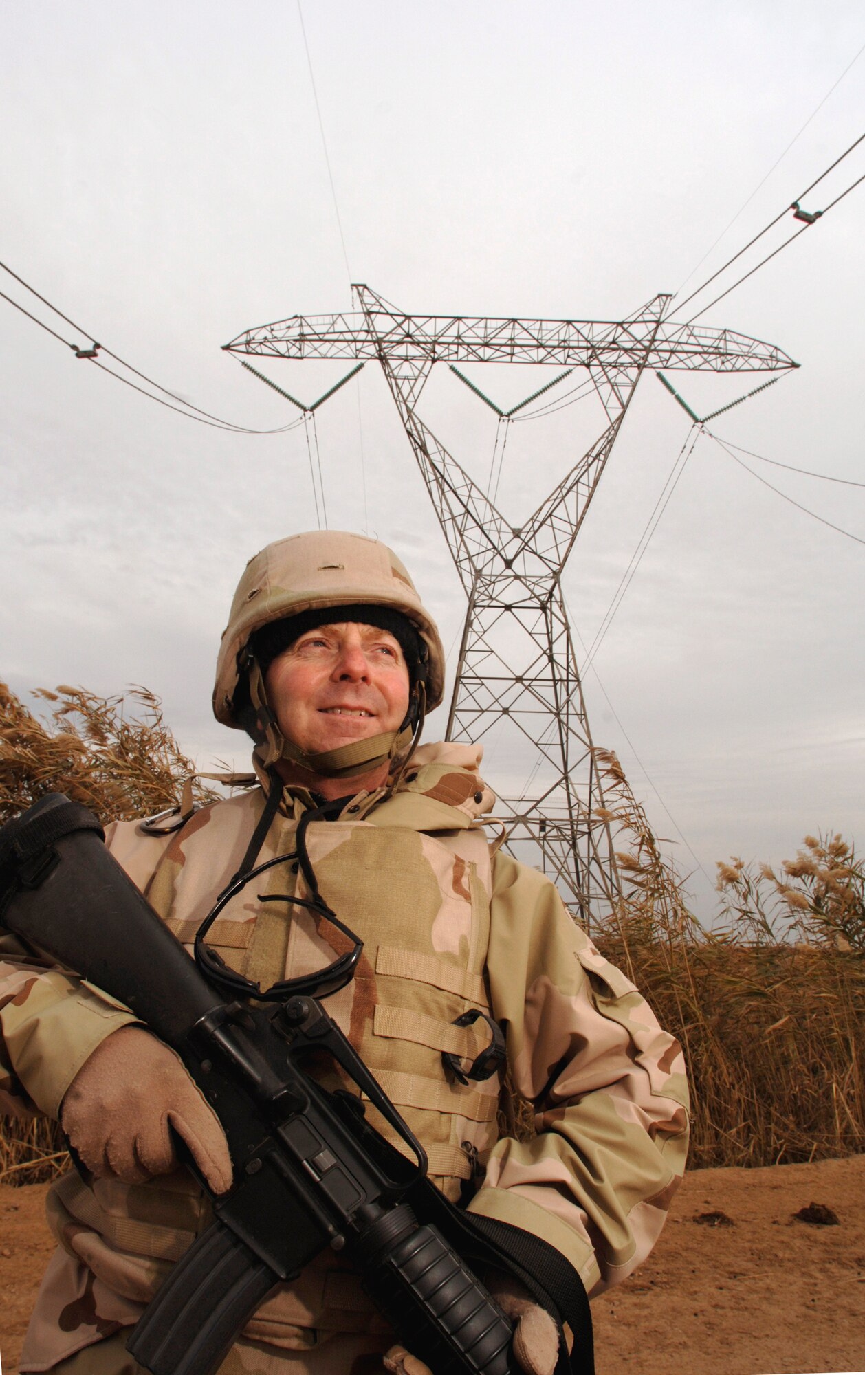 KIRKUK, Iraq (AFPN) -- Chief Master Sgt. Paul Kaplan inspects 400-megavolt power lines from the ground. The lines lost power after several towers were toppled at a pipeline canal crossing a few miles away. Chief Kaplan is a POInT member in charge of electricity. In his region, he aids the forward movement of the national power grid, which includes four major power plants. He is with the 732nd Expeditionary Civil Engineer Squadron here and deployed from the 60th Civil Engineering Squadron at Travis Air Force Base, Calif. (U.S. Air Force photo by Master Sgt. Lance Cheung)