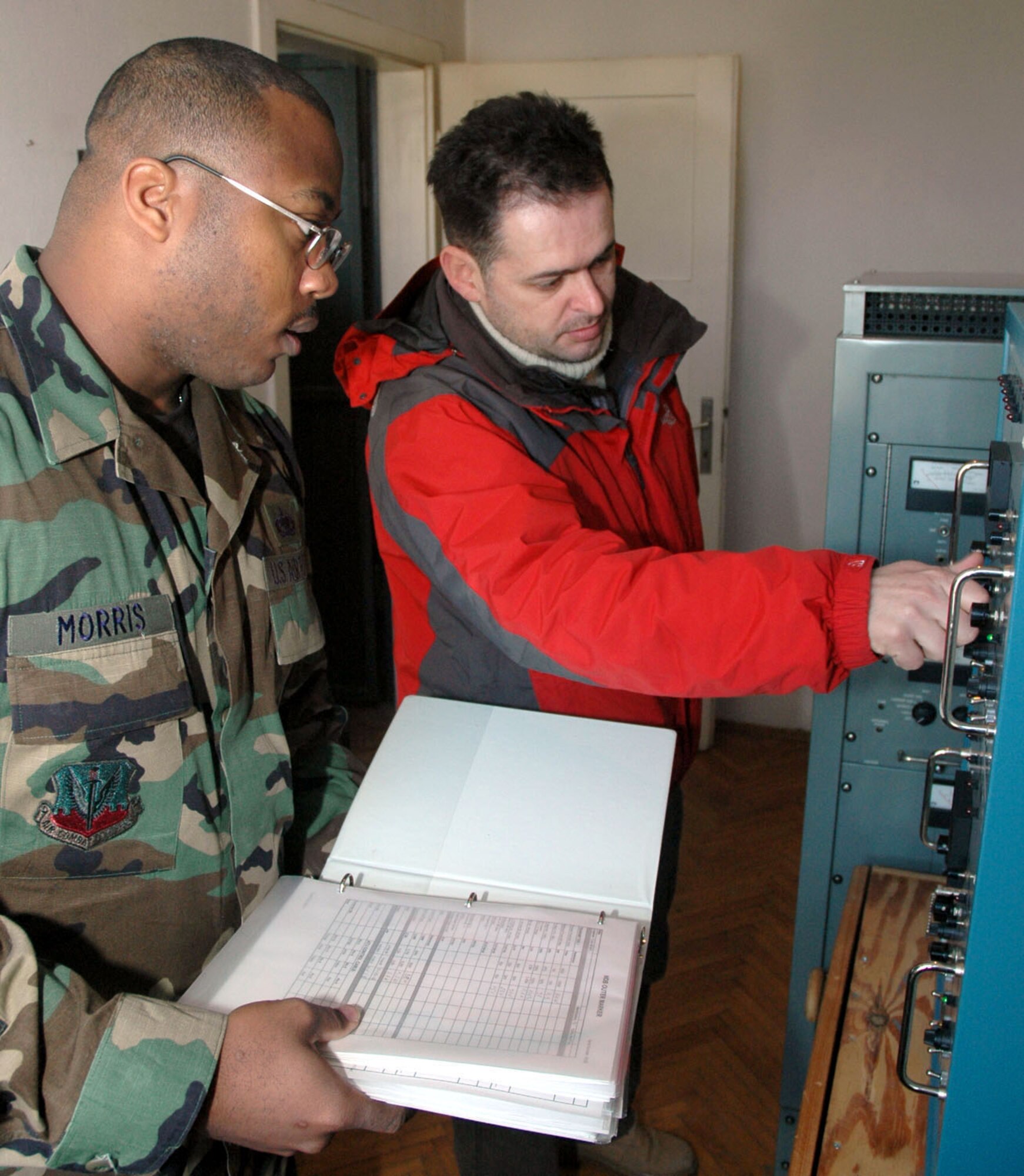 TUZLA AIR BASE, Bosnia and Herzegovina (AFPN) -- Staff Sgt. Mario Morris and Almir Pepeljak perform a preventive maintenance inspection of a non-directional beacon. Sergeant Morris is with the 401st Air Expeditionary Wing and Mr. Pepeljak is a contractor with Kellogg, Brown and Root. (U.S. Air Force photo by Master Sgt. Chance Babin)