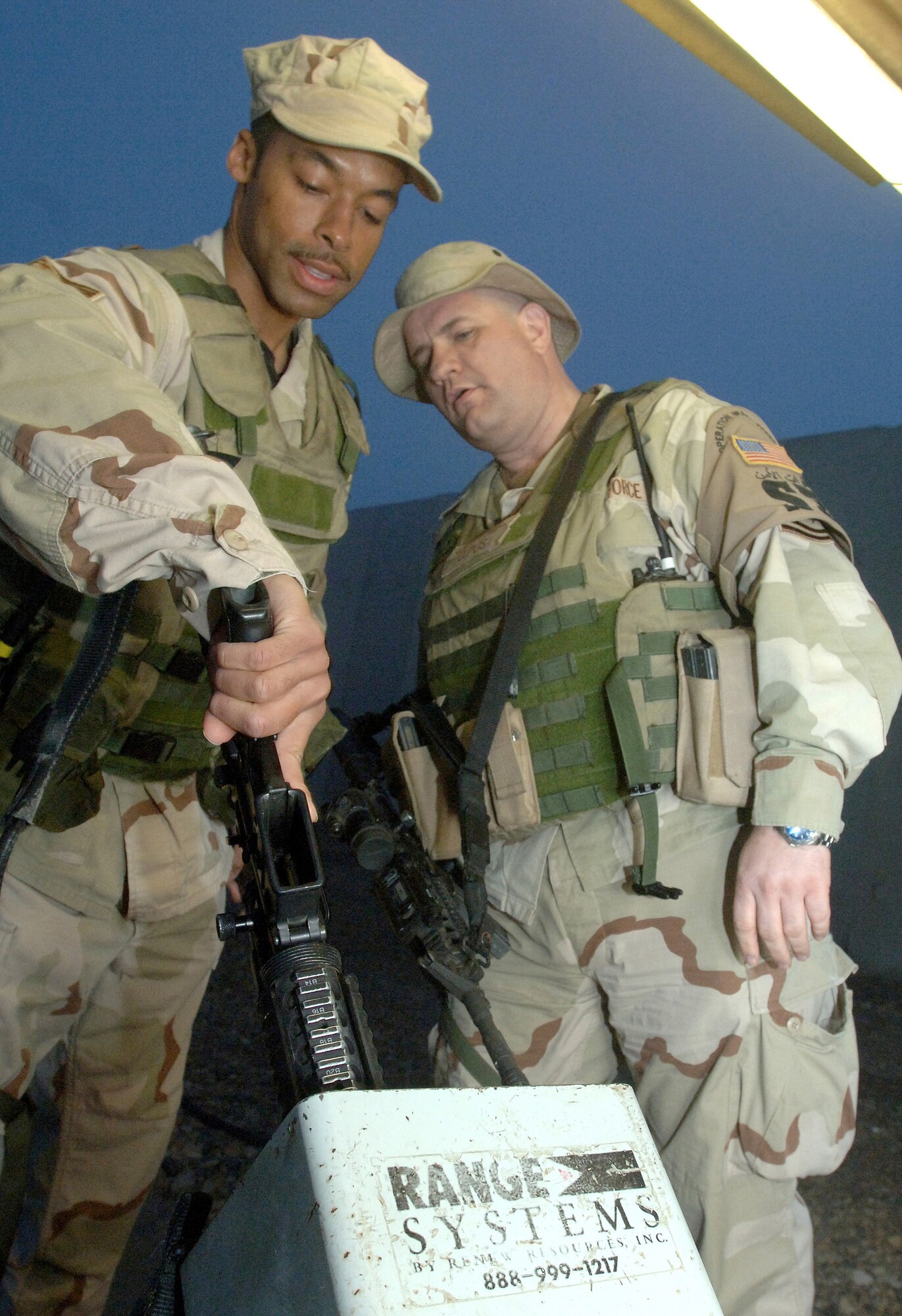 ALI BASE, Iraq (AFPN) -- Master Sgt. Brian Cottrill oversees proper clearing procedures with Staff Sgt. Tyreese McAllister Feb. 16.  Before security forces Airmen are relieved of duty their weapons must be cleared and cleaned before they are returned to the armory. Both are with the 407th Expeditionary Security Forces Squadron.  (U.S. Air Force photo by Staff Sgt. Valerie Smith)