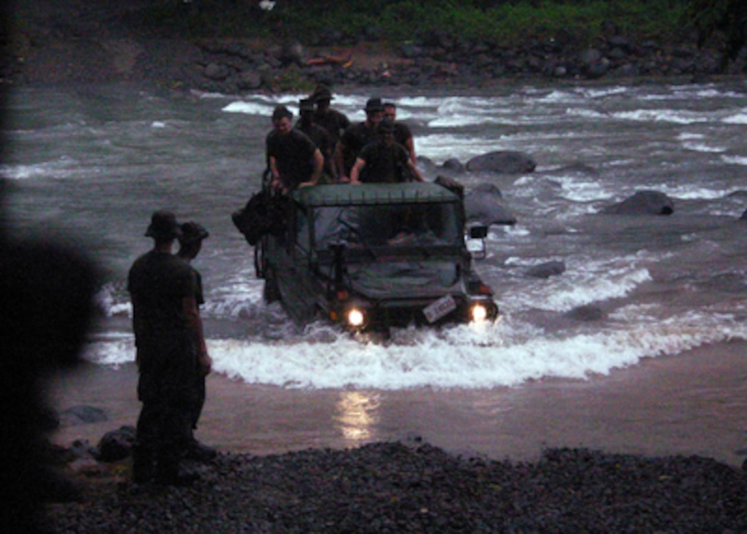 U.S. Marines ford a river as they return from search and rescue efforts in the village of Guinsaugon, Philippines, on Feb. 22, 2006. Sailors and Marines from the amphibious assault ship USS Essex (LHD 2) and the dock landing ship USS Harpers Ferry (LSD 49) are providing humanitarian assistance for the victims of the Feb. 17, 2006, landslide in the village of Guinsaugon on the island of Leyte. These Marines are attached to Echo 2, Battalion 5, 31st Marine Expeditionary Unit. 