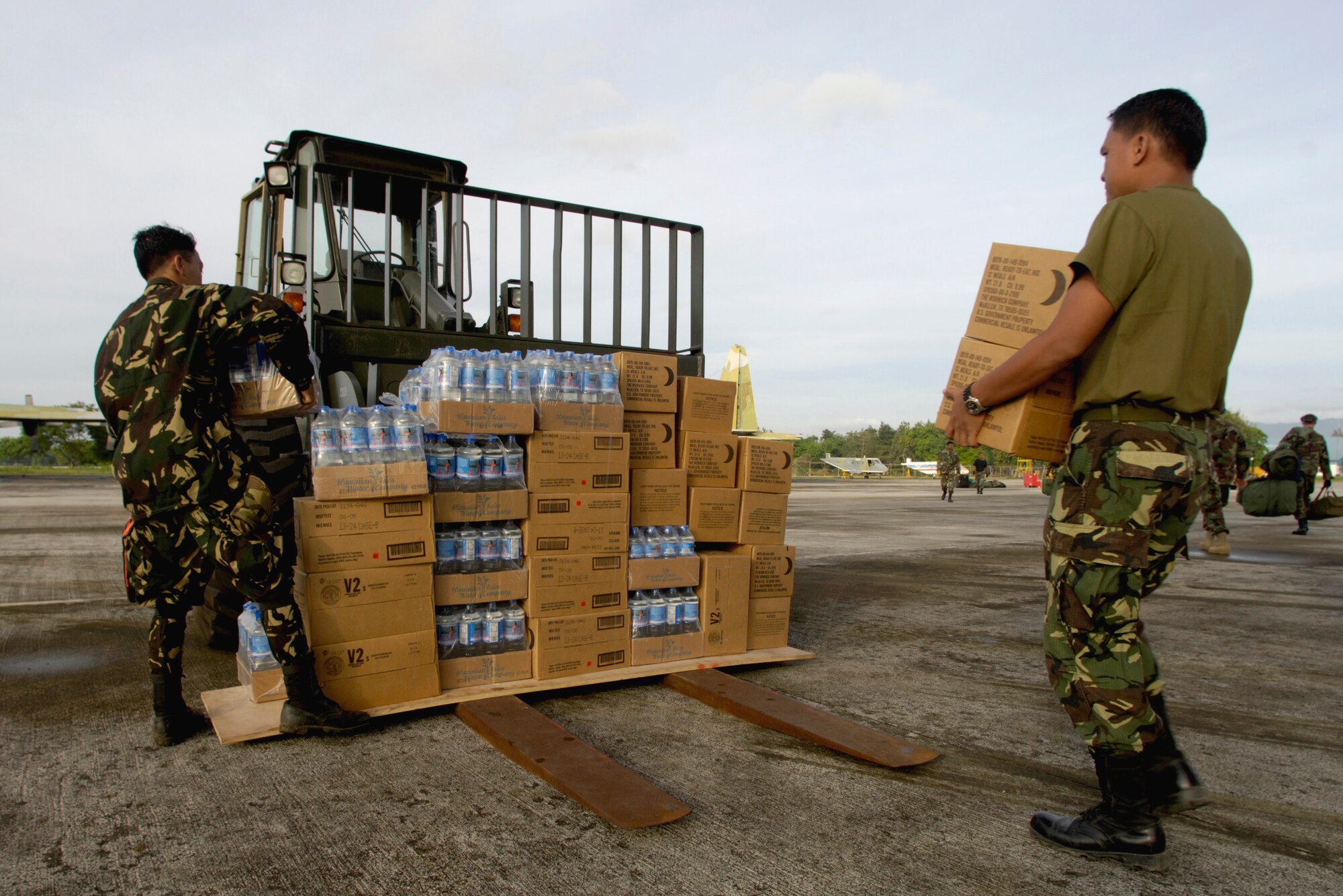 MACTAN AIR BASE, Philippines (AFPN) -- Philippine servicemembers download water and military rations from a C-17 Globemaster III. The composite C-17 squadron of active duty and Hawaii Air National Guard flew their first contingency response mission to deliver relief supplies to the Philippines Feb. 22. (U.S. Air Force Photo by Tech. Sgt. Shane A. Cuomo) 